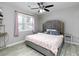 Cozy bedroom with a decorative headboard, a ceiling fan, and a large window at 551 Floyd Se Dr, Smyrna, GA 30082