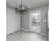 View of the kitchen area showing modern lighting fixture, tile floors and white door leading outside at 551 Floyd Se Dr, Smyrna, GA 30082
