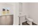 Powder room with pedestal sink and modern fixtures, adjacent to a large living area at 1591 Oakbrook Pond Place, Dacula, GA 30019