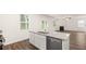 Modern kitchen featuring white cabinets and granite countertops that connects to the living area at 1591 Oakbrook Pond Place, Dacula, GA 30019