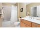 Well-lit bathroom with a combined shower and tub, featuring a white shower curtain and wood vanity at 1967 Mason Mill Rd, Decatur, GA 30033