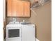 This laundry room features a modern washer and dryer with wooden cabinets above and a wire shelf at 1967 Mason Mill Rd, Decatur, GA 30033