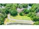 Aerial view showcases the surrounding lush greenery, road, and pond with tennis courts nearby at 41 Basswood Cir, Sandy Springs, GA 30328