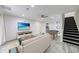 Spacious living room features modern flooring, a ceiling fan, stairs, and a television at 41 Basswood Cir, Sandy Springs, GA 30328