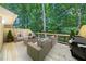 Outdoor deck with comfortable seating and a grill, surrounded by mature trees at 41 Basswood Cir, Sandy Springs, GA 30328