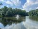 Picturesque pond with fountain surrounded by lush trees and blue skies at 41 Basswood Cir, Sandy Springs, GA 30328