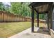View of the grassy backyard featuring a concrete patio and retaining wall at 4276 Lindsey Ne Way, Roswell, GA 30075