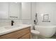 Bathroom with white tub, subway tile, and wood grain vanity at 4276 Lindsey Ne Way, Roswell, GA 30075