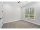 Bedroom with neutral carpet, large window with blinds, and trim details adding a touch of elegance at 4276 Lindsey Ne Way, Roswell, GA 30075