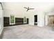 Large bedroom with a wood accent wall, ceiling fan, carpet floors, and doorways to a bathroom and hallway at 4276 Lindsey Ne Way, Roswell, GA 30075