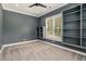 Carpeted bedroom with built-in shelving, a ceiling fan, and natural light through a window overlooking backyard foliage at 4276 Lindsey Ne Way, Roswell, GA 30075
