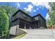 Modern two-story home with dark siding, a two-car garage, and beautiful natural landscaping at 4276 Lindsey Ne Way, Roswell, GA 30075