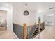 Hallway with wood floors, black metal railing, a modern pendant light, and access to a bathroom with a glass shower at 4276 Lindsey Ne Way, Roswell, GA 30075