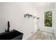 Well-lit laundry room featuring a black sink and modern hanging rack at 4276 Lindsey Ne Way, Roswell, GA 30075