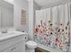 Bright bathroom with a white vanity, floral shower curtain, and modern fixtures at 779 Sanders Rd, Cumming, GA 30041