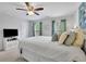 Cozy bedroom with large bed, ceiling fan, curtains, and TV stand featuring a TV and storage at 779 Sanders Rd, Cumming, GA 30041