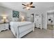 Comfortable bedroom with ample lighting, a large bed with plush pillows, and stylish, white furniture pieces at 779 Sanders Rd, Cumming, GA 30041