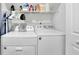 Functional laundry room with a washer, dryer, and shelving for storage at 779 Sanders Rd, Cumming, GA 30041
