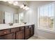 Well lit bathroom featuring a double vanity, large mirror, and natural light at 1188 Parktown Dr, Mableton, GA 30126