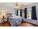 Cozy bedroom features hardwood floors, two windows, and a ceiling fan with decorative lighting at 1274 Ridge Vista Ct, Lawrenceville, GA 30043
