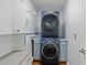 Convenient laundry room with modern stacked washer and dryer, and storage cabinets at 1274 Ridge Vista Ct, Lawrenceville, GA 30043
