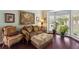 Cozy living room with bay windows, tapestry, comfortable seating, and beautiful hardwood floors at 1274 Ridge Vista Ct, Lawrenceville, GA 30043