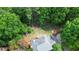 Aerial shot of home nestled in lush landscaping with a fire pit in the backyard at 2005 Sweetgum Trl, Cumming, GA 30041