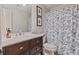 Bathroom featuring a vanity with wood cabinets, stone countertop, and a blue floral shower curtain at 2005 Sweetgum Trl, Cumming, GA 30041