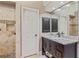 Stylish bathroom with a stone shower, dark cabinets, a granite countertop, and a decorative mirror at 2005 Sweetgum Trl, Cumming, GA 30041