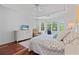 Large bedroom offers hardwood floors, a ceiling fan, and a view of the backyard through bright windows at 2005 Sweetgum Trl, Cumming, GA 30041