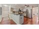 Well-lit kitchen includes stainless steel appliances, granite countertops, and a breakfast bar for casual dining at 2005 Sweetgum Trl, Cumming, GA 30041