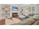 Inviting living room features a cozy fireplace, built-in shelves, and large windows overlooking the backyard at 2005 Sweetgum Trl, Cumming, GA 30041