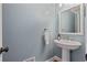 Stylish powder room with a pedestal sink and modern fixtures at 2005 Sweetgum Trl, Cumming, GA 30041