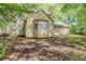 Back exterior of a home with an attached garage and a partially shaded backyard at 5786 Longbow Dr, Stone Mountain, GA 30087