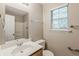A bathroom with a white sink, mirror, toilet, and a window allowing natural light at 5786 Longbow Dr, Stone Mountain, GA 30087