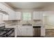 Bright kitchen with white cabinets, laminate countertops, and stainless appliances at 5786 Longbow Dr, Stone Mountain, GA 30087