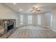 Cozy living room showcasing a stone fireplace, ceiling fan, and three large windows at 5786 Longbow Dr, Stone Mountain, GA 30087