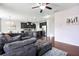 Open concept living room featuring a large sectional, hardwood floors, and kitchen with stainless steel appliances at 5830 Keystone Pt, Lithonia, GA 30058