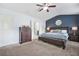 Spacious main bedroom featuring dark wood furniture, a ceiling fan, and neutral carpet at 5830 Keystone Pt, Lithonia, GA 30058
