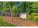 Landscaped backyard featuring a wooden fence, shed, and wooden archway at 963 Hawk Creek Trl, Lawrenceville, GA 30043