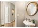 Bathroom with a pedestal sink, decorative mirror, and access to other rooms at 963 Hawk Creek Trl, Lawrenceville, GA 30043