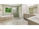 Bright bathroom with tiled floor, soaking tub, and glass shower enclosure at 963 Hawk Creek Trl, Lawrenceville, GA 30043