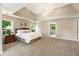 Spacious main bedroom with large bed, tray ceiling, and neutral decor at 963 Hawk Creek Trl, Lawrenceville, GA 30043