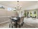 Dining room with table and seating for eight, plush carpet, and natural light from the large surrounding windows at 963 Hawk Creek Trl, Lawrenceville, GA 30043