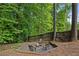 Backyard fire pit with mature trees, and wooden fence at 963 Hawk Creek Trl, Lawrenceville, GA 30043