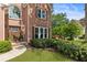 Close-up of the front of a brick home featuring an arched window, covered porch, and well-maintained landscaping at 963 Hawk Creek Trl, Lawrenceville, GA 30043