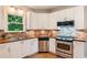 Bright kitchen features white cabinets, stainless steel appliances, hardwood floors and tiled backsplash at 963 Hawk Creek Trl, Lawrenceville, GA 30043