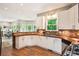 Bright open kitchen with white cabinets, butcher block counters and access to living room at 963 Hawk Creek Trl, Lawrenceville, GA 30043