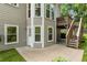 Backyard patio with steps to the deck overlooks a lush green lawn and wooded area at 963 Hawk Creek Trl, Lawrenceville, GA 30043