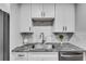Close-up of kitchen featuring granite countertops, stainless sink and modern appliances at 1015 Dunbar Dr, Dunwoody, GA 30338